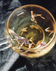glass cup with blue lotus tea petals