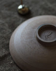 Close-up of a ceramic incense holder on a textured surface